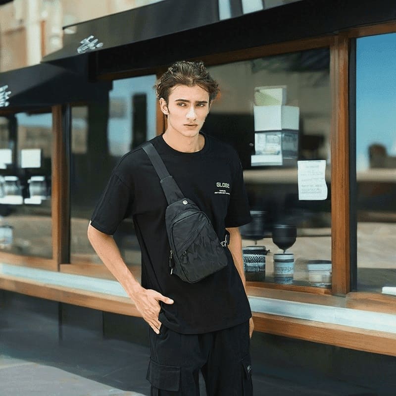 A model shows off a black street pop crossbody bag and an urban-style Oxford Fanny pack