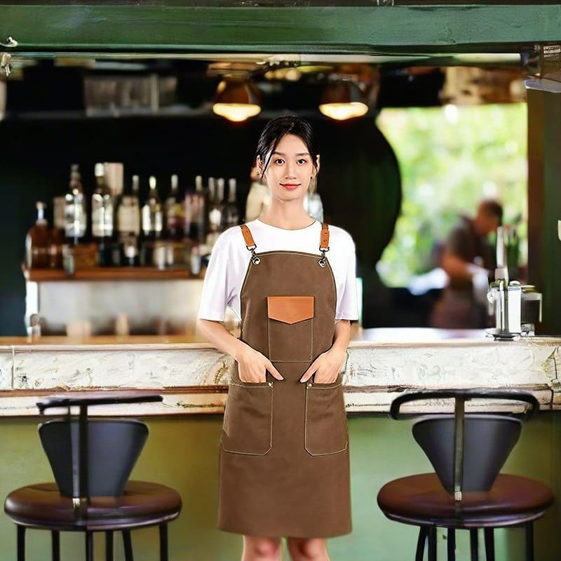 Fashion models play the role of professional baristas in the cafe scene showing coffee colored aprons to show the wearing effect- View Image